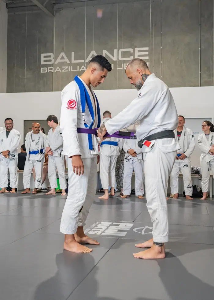 A Balance BJJ member training in the gi on the mats