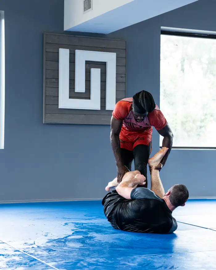 A student working with Coach Bones in No-Gi
