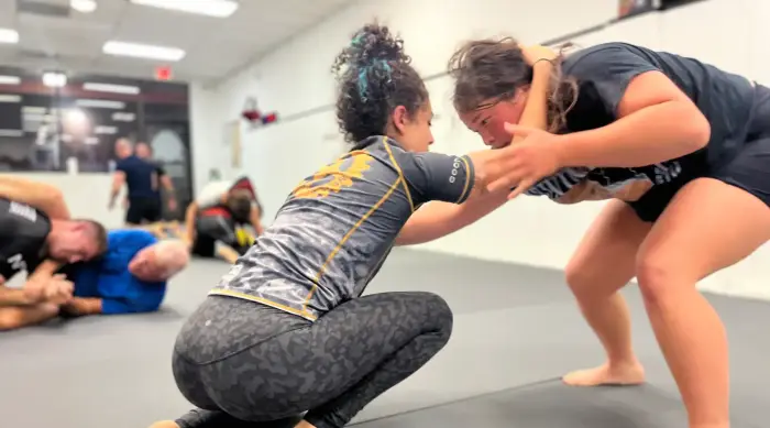 Two students battling for grips in a no-gi submission grappling class at Close Quarters