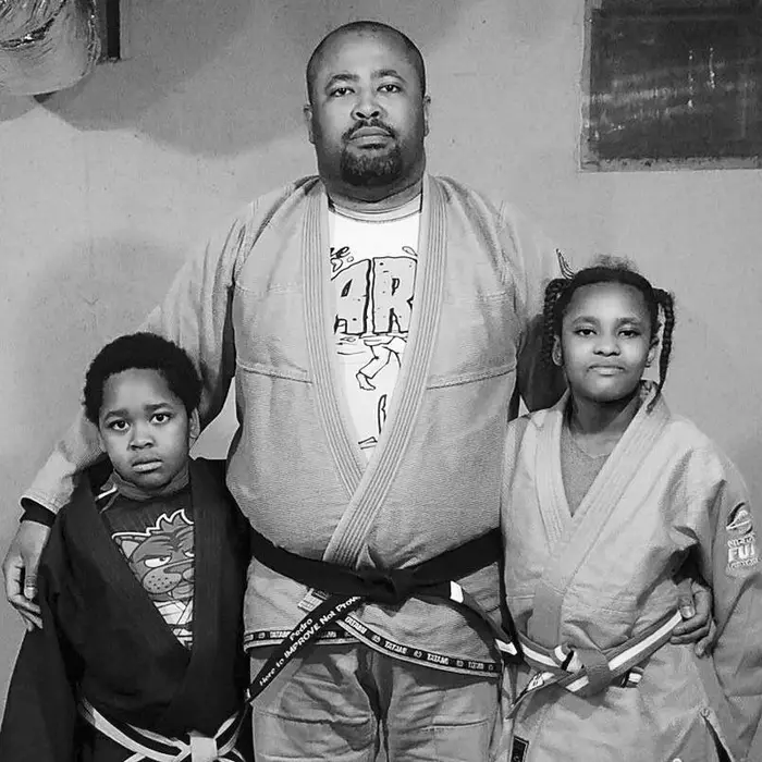 Black belt instructor with two young students in their gis
