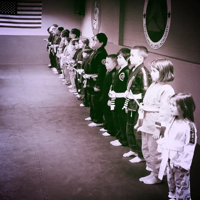 Crossover BJJ students training Brazilian Jiu-Jitsu on the mats
