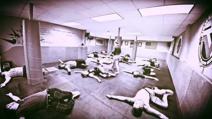 Adults rolling during a Crossover BJJ class