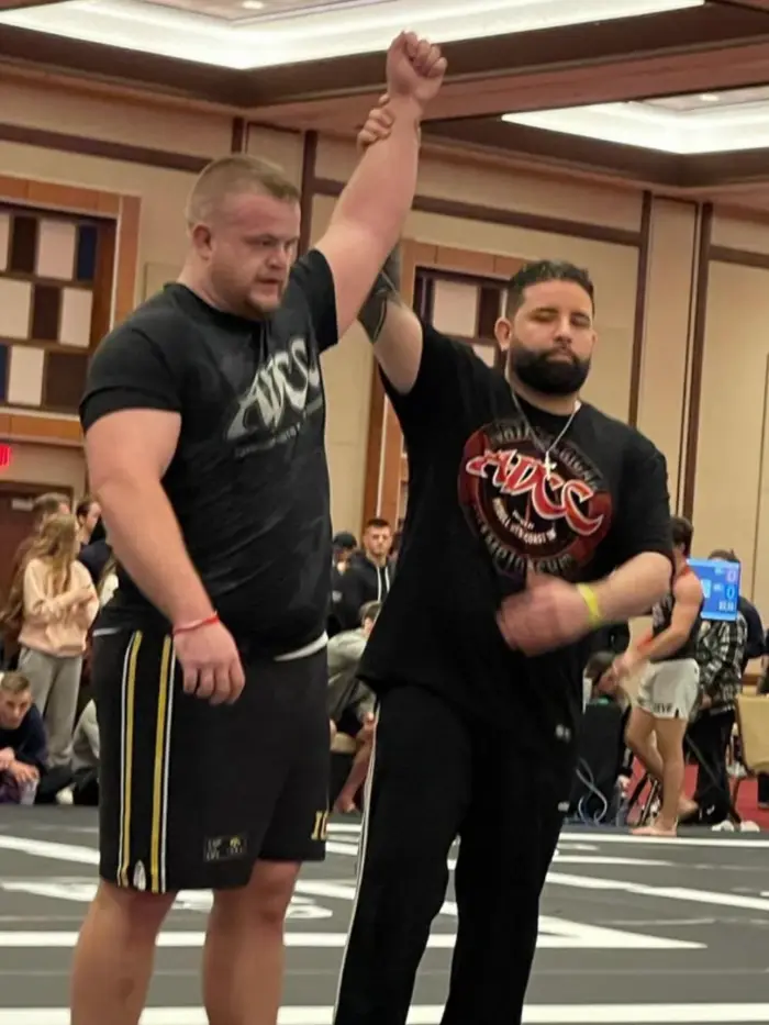 Coach Paxton Titus with an athlete at a powerlifting competition