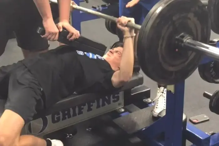 Athlete pressing a loaded barbell overhead