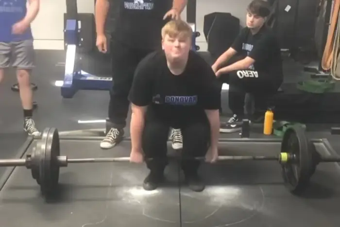 Young athlete braced at the bottom of a heavy deadlift