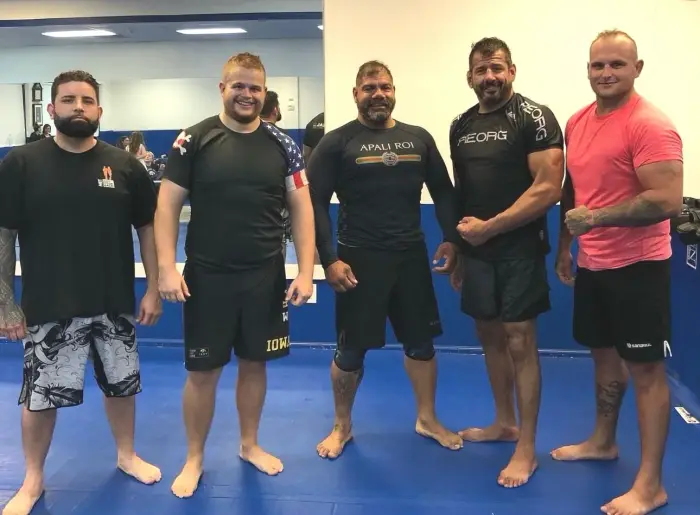 Coach Titus with grappling training partners on the mats