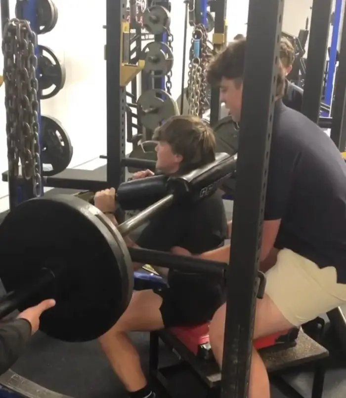 Athlete bracing under a loaded barbell back squat
