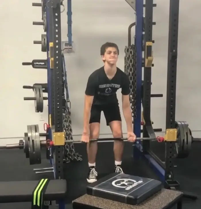 Athlete preparing for a barbell deadlift in the training hall