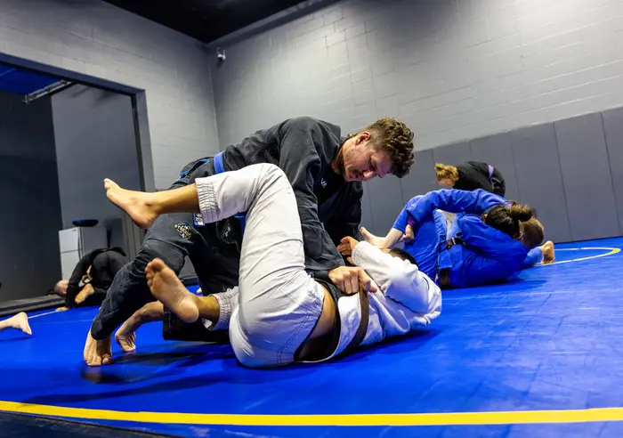 Coach guiding live grappling on the mats at Hamel Jiu Jitsu
