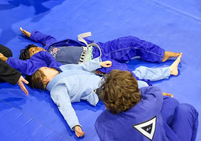 Partners rolling during class on the blue Zebra mats