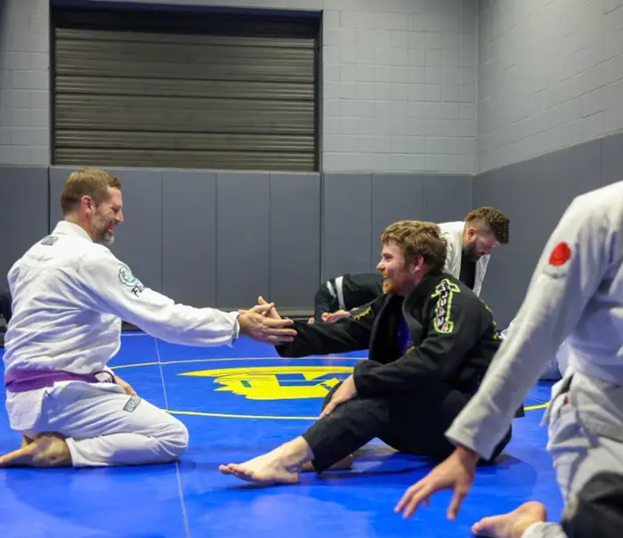 Teammates shaking hands before rolling on the mats