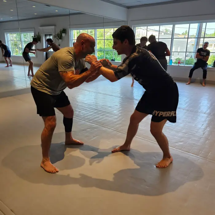 Students training jiujitsu on the mats at On Top Jiujitsu