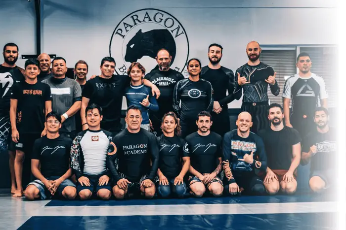 Paragon Simi Valley adult team gathered in front of the Paragon panther wall logo