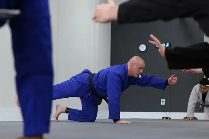 Two students rolling in the gi during a Brazilian Jiu Jitsu class at Teddy's Jiu Jitsu Academy