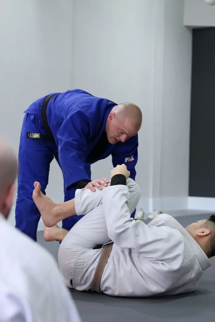 Student in a white gi training Brazilian Jiu Jitsu