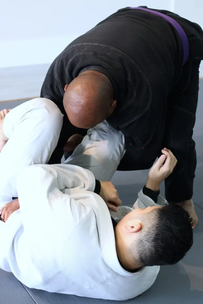 Jiu Jitsu student in a gi on the mats at the academy