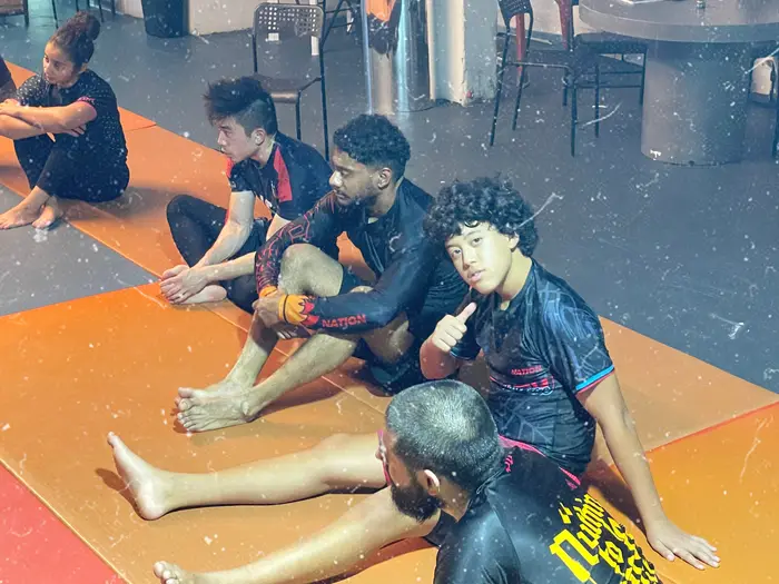 Students gathered on the mats after a No-Gi training session at The Jiu Jitsu Lounge