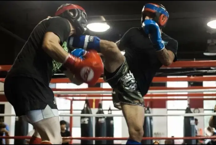 Kickboxing sparring with headgear and gloves in the ring
