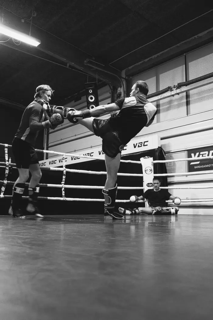 A Muay Thai fighter throwing a high kick in the VBC ring