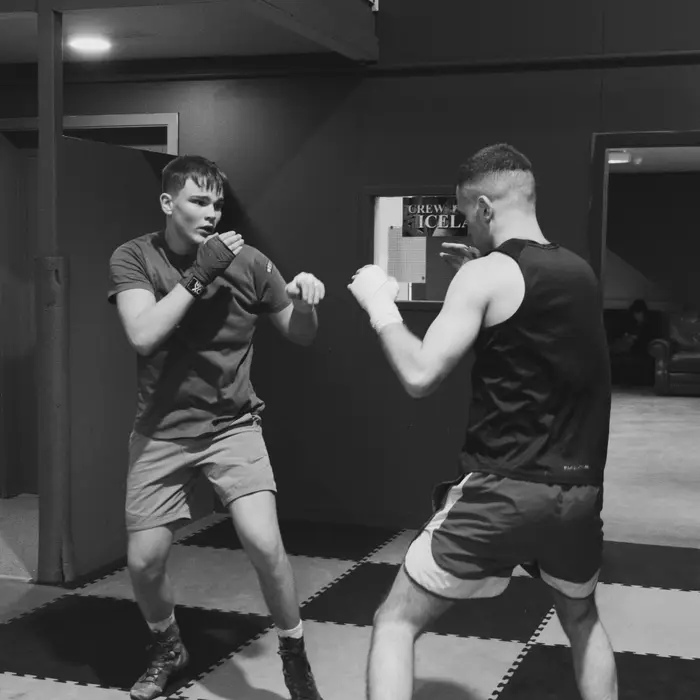 A coach teaching grip work to a young grappler at VBC